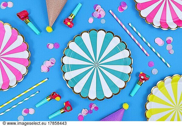 Party flat lay with paper plates  drinking straws and confetti on blue background