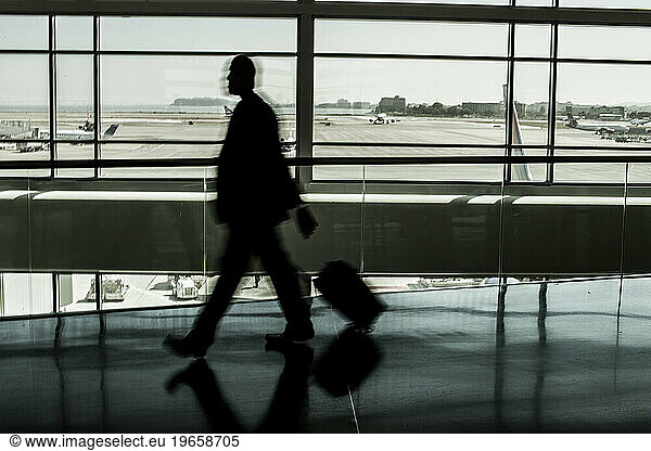 Passenger walking through a modern airport.