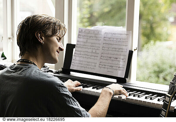 Passionate young man playing piano at home