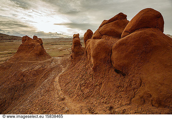 path winds its way up bulbous red clay sandstone formations at dusk