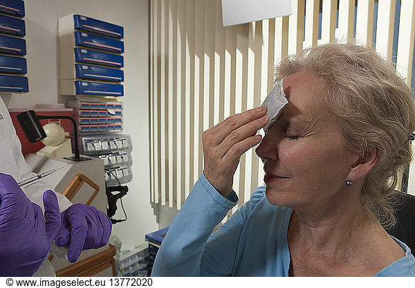 Patient applying ice on her forehead after a Botox treatment