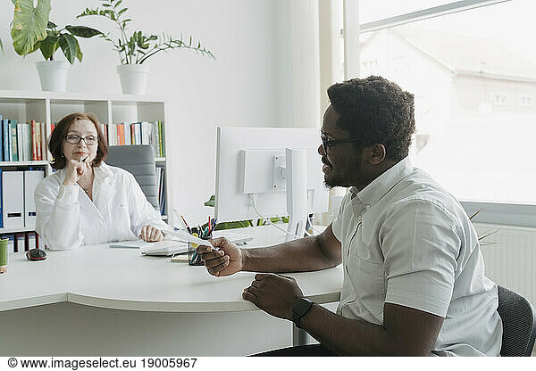 Patient discussing medical record with doctor in office