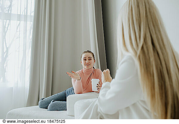 Patient having coffee and talking with psychologist in clinic