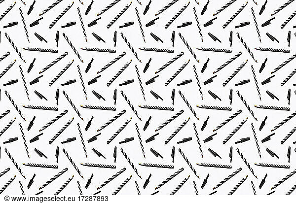 Pattern of black and white striped pens flat laid against white background