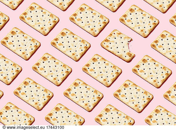 Pattern of crackers flat laid against pink background