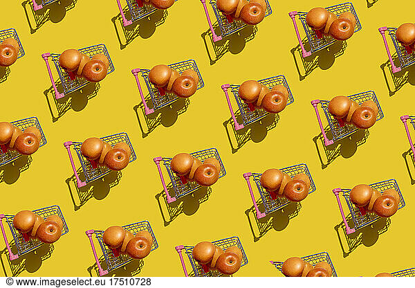 Pattern of fresh apricots inside miniature shopping carts
