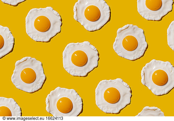 Pattern of fried eggs against yellow background
