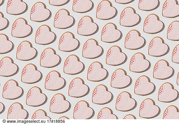 Pattern of heart shaped cookies flat laid against white background