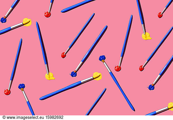 Pattern of paintbrushes with blue  red and yellow oil paint
