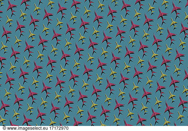 Pattern of pink and yellow origami airplanes