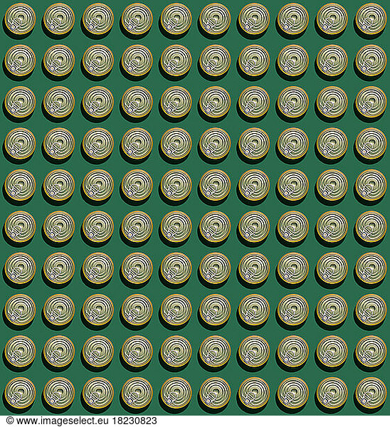 Pattern of rows of cans flat laid against green background
