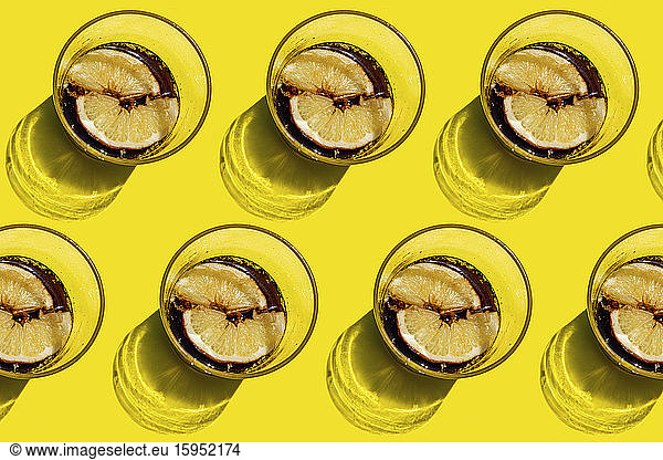 Pattern of rows of cola glasses with lemon slices