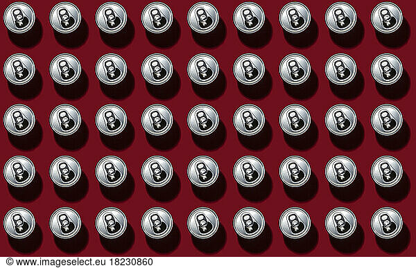 Pattern of rows of drink cans standing against red background