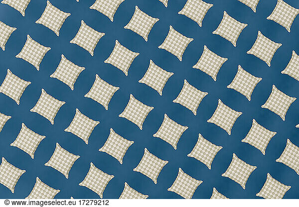 Pattern of white checked cushions against blue background