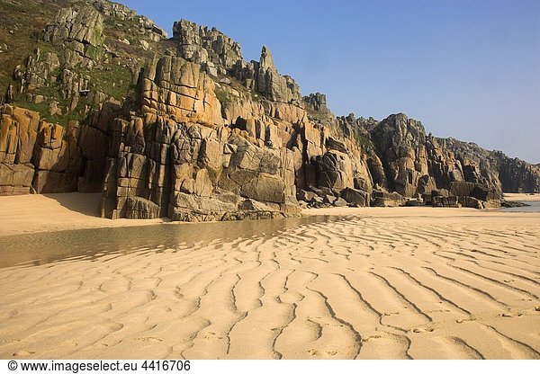 Patterns in the Sand on Pendnvounder Beach with Treen Cliffs in the background Cornwall