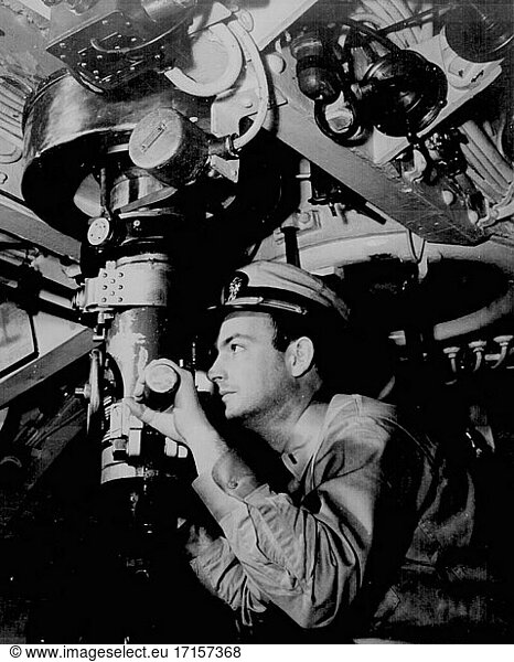 Pazifischer Ozean -- 1943 -- Ein Offizier der US Navy blickt durch ein Periskop im Kontrollraum eines amerikanischen U-Boots -- Bild von Lightroom Photos / US Navy *NB Nicht auf Staub und Kratzer retuschiert.