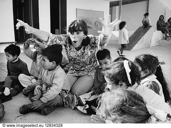 PEACE CORPS: TUNISIA. Peace Corps volunteer Diana Roberts playing with young children in Sousse,  Tunisia. Photograph,  c1967.