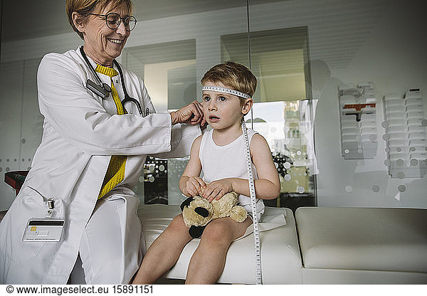 Pediatrician measuring extent of child?s head
