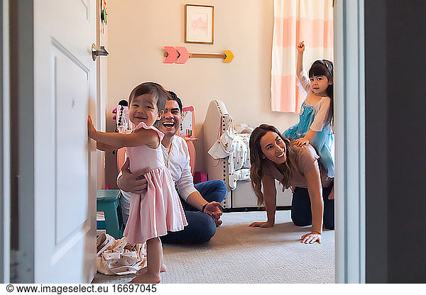 Peeking into a bedroom while family of four are playing together.