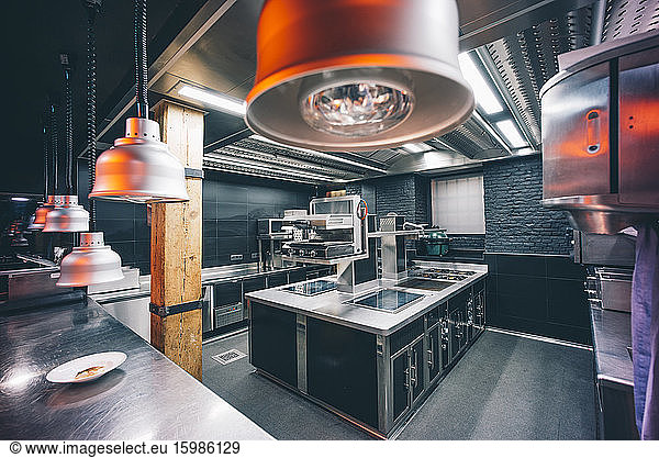 Pendant lights hanging on counter in commercial kitchen at restaurant