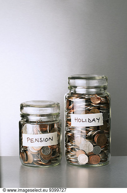 Pension and holiday change savings jars on counter