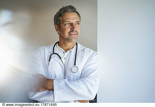 Pensive doctor with arms crossed looking away