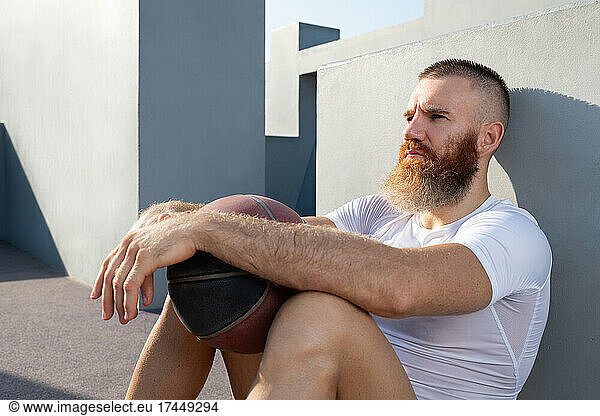 Pensive sportsman with basketball ball