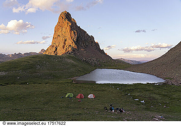 People camping by mountain lake during vacation