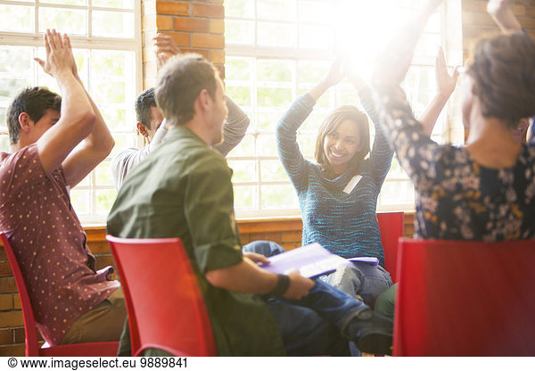 People clapping overhead in group therapy session