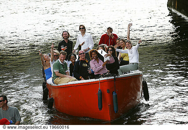People cruising their boat at a canal  Amsterdam  Holland.