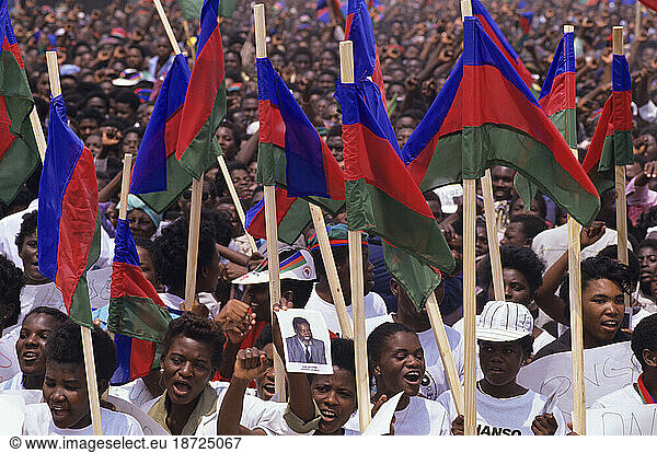 People holding flags high at an election rally in Namibia.