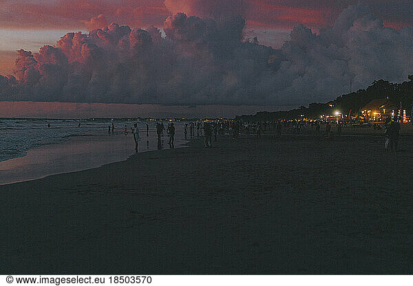 People on the ocean beach watch the sunset. Bali  Indonesia.