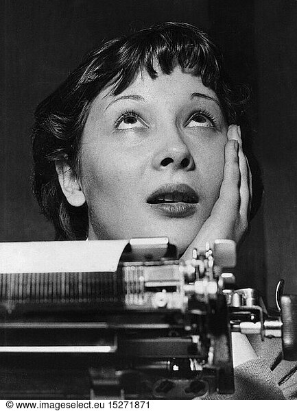 people  professions  secretary  behind her typewriter looking up  1960s