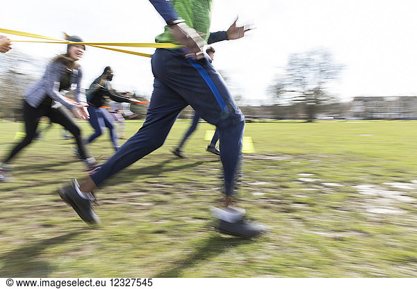 People racing  doing team building exercise in sunny park