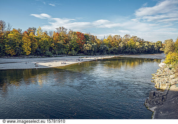 People relaxing at Isar river in Northern English Garden in autumn  Oberfohring  Munich  Germany