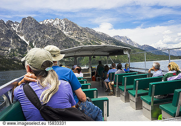 People riding the Ferry Boat on Jenny Lake with the Teton Range behind