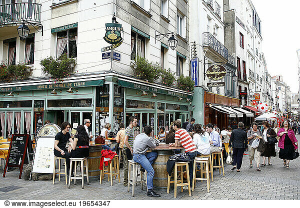 People sitting at an outdoors cafe in a pedestrian street  Nantes  Brittany  France.
