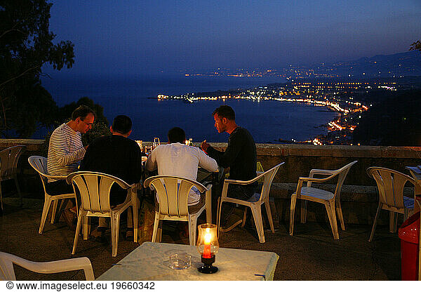 People sitting at an outdoors restaurant in Taormina  Sicily  Italy