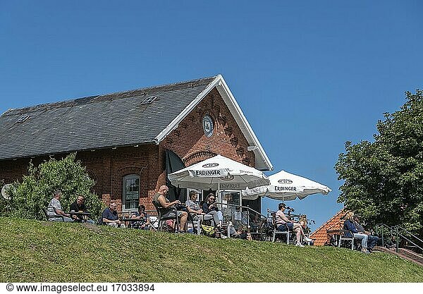 People sitting in the cafe at the flood embankment  Greetsiel  Lower Saxony  Germany  Europe.