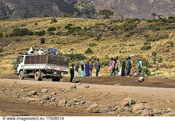 People stand in the back of a truck and on the side of the road in the Simien Mountains of rural Ethiopia Semien National Park; Ethiopia