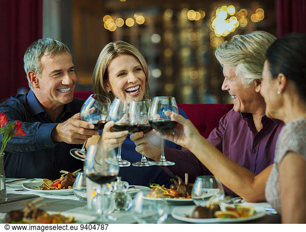 People toasting with red wine in restaurant