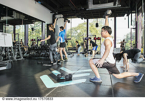 people working out during group fitness training at gym in Bangkok