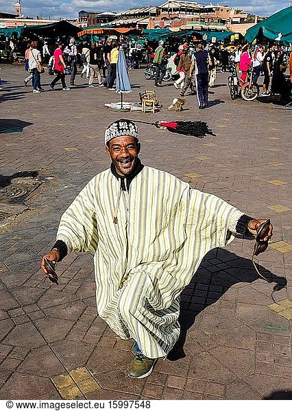 Percussionist in traditional costume entertaining tourists in the Jemaa El Fna  a world heritage site  Marrakech  Morocco.