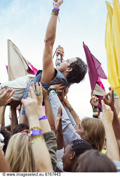 Performer crowd surfing at music festival