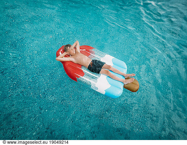 Person floating on red white and blue popsicle swimming pool flo