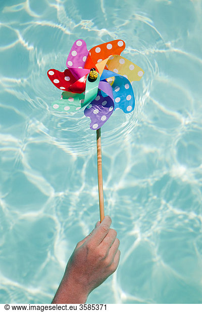 Person holding pinwheel in swimming pool