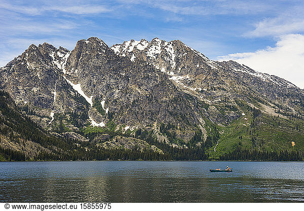 Person in einem Kanu beim Angeln im Jenny Lake  dahinter die Berge