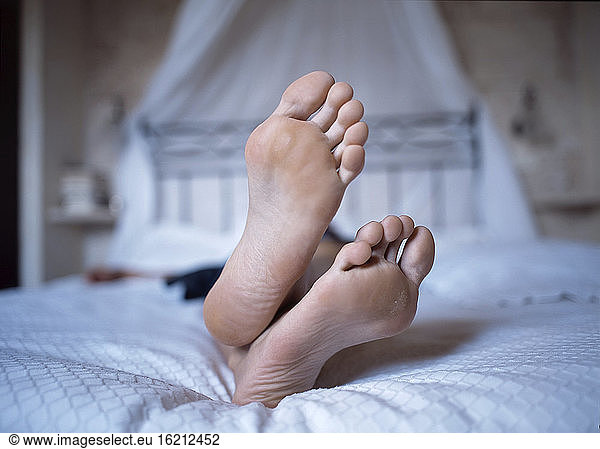 Person lying on bed  close up of feet