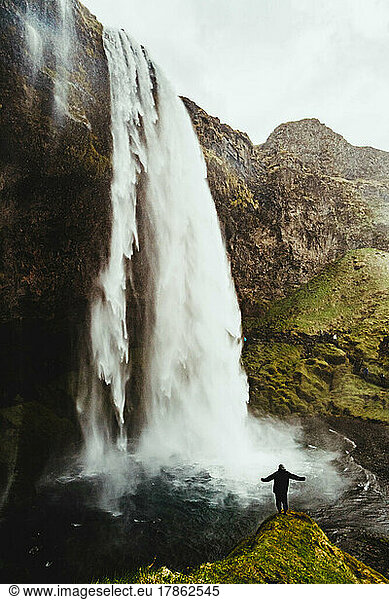 person on a pinion looking at a large waterfall