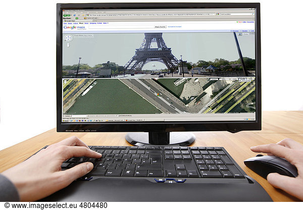 Person sitzt am Computer  arbeitet mit Google Street View  Über Google Maps  im Internet  Ansicht von Pariser Straßen  Eiffelturm